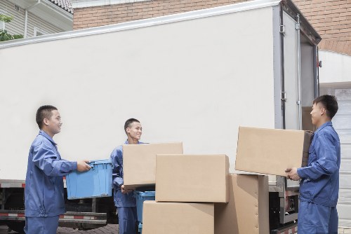 Worker carrying boxed items carefully during a man and van service